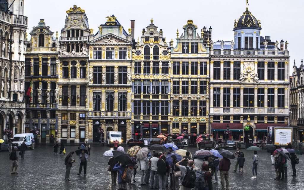 The gilded guildhall facades of the Grand Place in Brussels on a rainy day