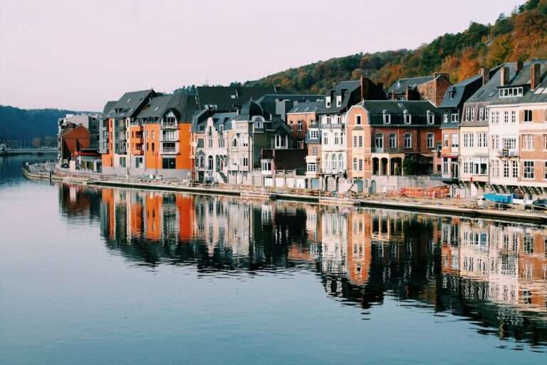Townhouses along the River Meuse at Dinant, reflected in still water
